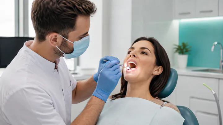 A Winnipeg dentist carefully examining a patient’s mouth during an oral cancer check