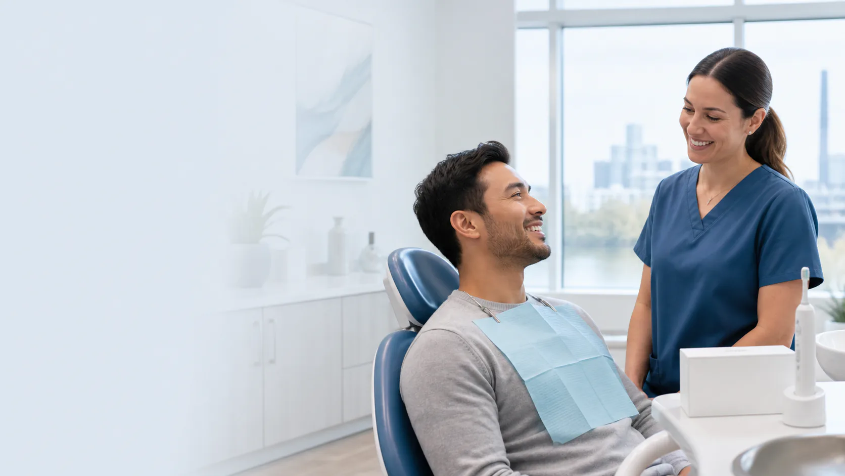 A smiling dental patient speaking with a hygienist after a cleaning appointment