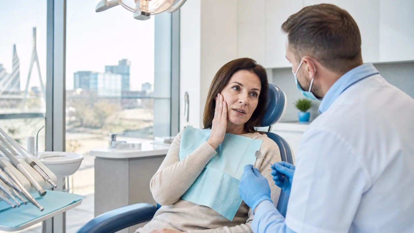 A compassionate dentist listening to a patient experiencing sudden tooth pain
