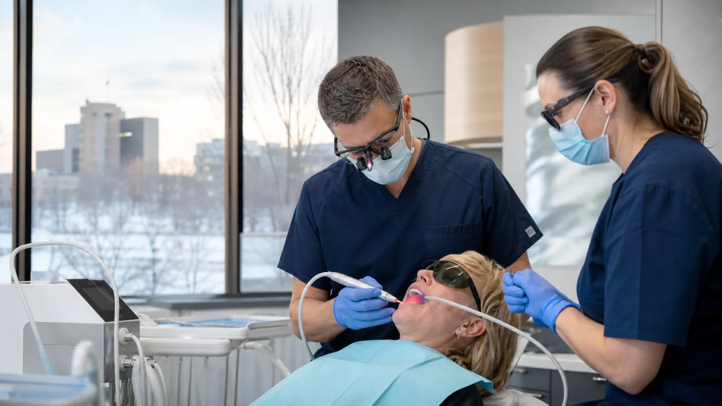 A dental team using laser technology during a precise clinical procedure